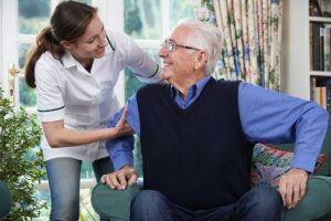 Caregivers assisting several older adults with daily activities in a communal assisted living space.